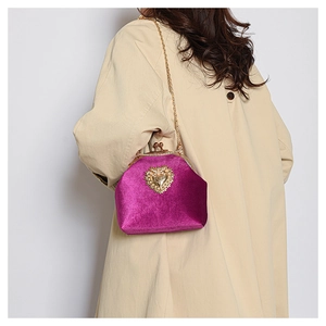 Dettaglio mini borsa in velluto viola con ciondolo a cuore di perle e tracolla dorata