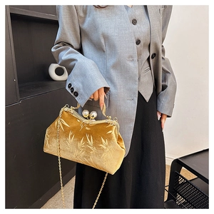 Detail of vintage yellow velvet clutch bag featuring bamboo patterns and pearl clasp