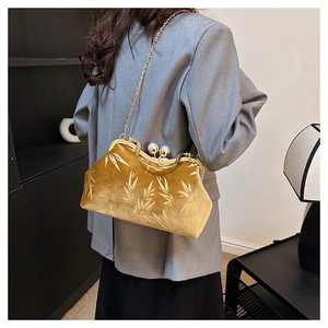 Close-up of golden velvet shell bag with bamboo leaf jacquard and large pearl clasp