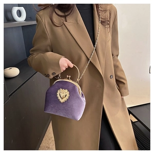 Dettaglio borsa da sera in velluto viola con rilievo in metallo dorato a forma di cuore