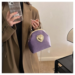 Dettaglio borsa da sera in velluto viola con chiusura a cuore dorata e manico