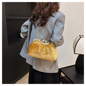 Detailed close-up of a gold velvet shell evening bag with elegant bamboo leaf texture