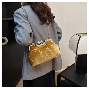 Detail of gold velvet shell bag with bamboo leaf pattern and pearl clasp closure