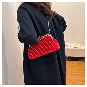 Detailed view of red velvet shell bag with gold chain and vintage metal clasp