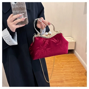 Detail of vintage burgundy velvet bag with bamboo pattern, pearl clasp and metal handle