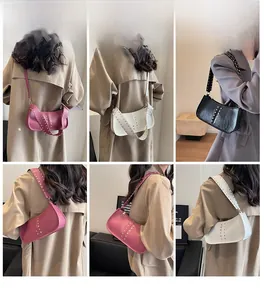 Detailed view of fashionable crossbody crescent bags with rivets and wide straps