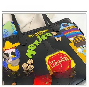 Detailed view of Mexican themed embroidery and Tequila patch on the black tote bag