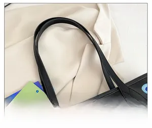Detail of embroidered floral patterns and reinforced shoulder strap on black tote bag