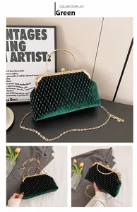 Detail of emerald velvet evening bag with gold embroidery and pearl clasp closure