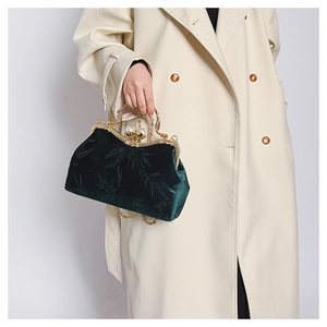 Detail of dark green velvet bag with bamboo leaf pattern and pearl clasp closure