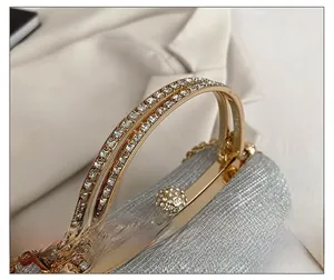 Macro shot of silver sequin evening bag with rhinestone handle and round crystal clasp