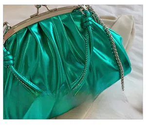 Détail du sac à main plissé vert métallisé avec cadre argenté et bandoulière