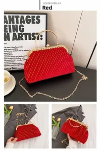 Macro shot of red velvet shell clutch with golden hardware and pearl clasp detail
