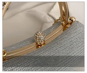 Detail of silver glitter evening clutch featuring a round rhinestone-encrusted clasp
