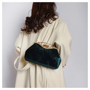 Detail of dark green velvet shell bag with bamboo jacquard pattern and pearl clasp
