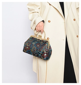 Detail of vintage floral embroidery on blue silk satin handbag with gold clasp