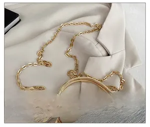 Close-up of golden metal chain strap and sparkling rhinestone detail on a small bag
