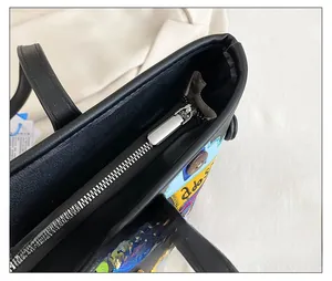 Detail of a black tote bag featuring a smooth silver metal zipper and colorful embroidery