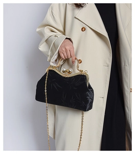 Detailed view of black vintage shell bag with jacquard leaf pattern and pearl clasp