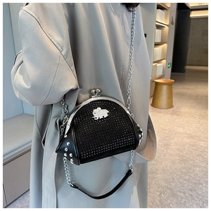 Detail of black rhinestone seashell bag with silver elephant motif and metal chain strap
