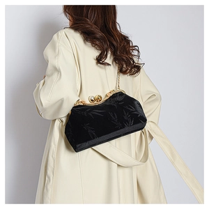 Detail of black velvet evening clutch with gold bamboo embroidery and pearl clasp
