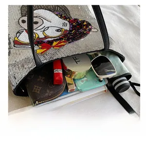 Silver sequin tote bag with cartoon print showing large capacity for daily essentials