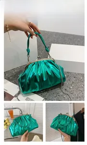 Détail du sac dumpling en cuir verni métallisé vert avec cadre en métal et bandoulière