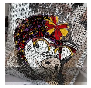 Detailed view of silver sequin tote bag with colorful cartoon pig embroidery and bow