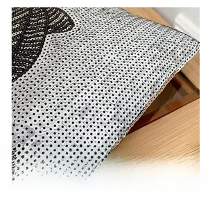 Macro shot of silver and black sequins on a large tote bag over a wooden table
