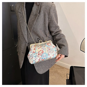 Close-up of floral embroidery on a vintage Chinese style clutch bag with metal chain
