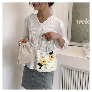 Detail of white handmade crochet bucket bag with sunflower accents and pearl strap