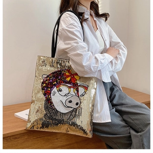 Detail of sequined gold tote bag featuring a cute cartoon pig print for women