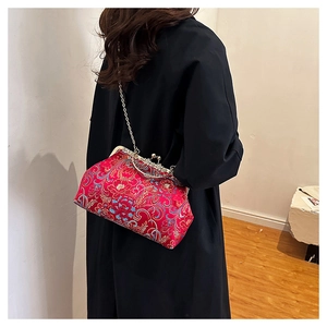 Detail of red floral embroidery on vintage satin clutch with metal frame closure