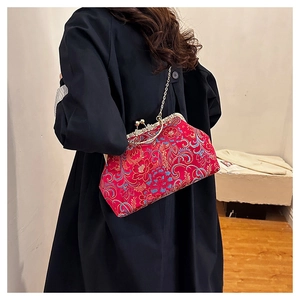 Detail of red Chinese embroidery evening bag with golden clasp and floral silk patterns