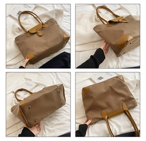 Detail view of large brown tote bag showing reinforced corners and metal protective feet