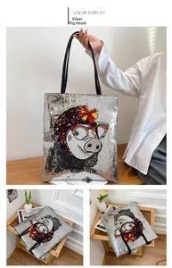 Detail of silver sequin tote bag featuring cartoon pig embroidery and black straps
