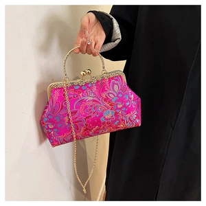 Close-up of rose pink satin evening bag with floral embroidery and gold metal clasp