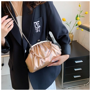 Détail du sac à main doré brillant avec fermoir vintage et bandoulière chaîne