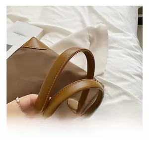 Close-up of brown Oxford tote handle with reinforced stitching and waterproof texture
