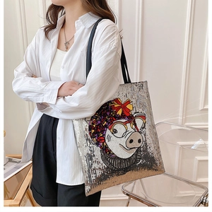 Detail of sequin tote bag featuring a cute cartoon pig with a red bow and round glasses