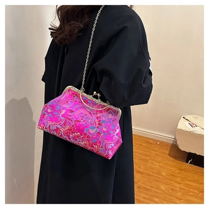 Detail view of pink satin evening bag with floral embroidery and gold chain strap