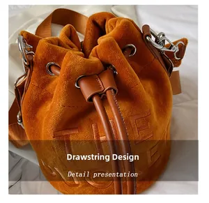 Detail of caramel velvet bucket bag featuring embroidered logo and drawstring closure