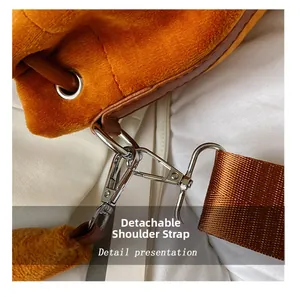 Detail of orange plush bucket bag featuring brown leather trim and detachable strap