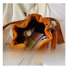 Spacious velvet drawstring bucket bag in caramel showing daily essentials inside