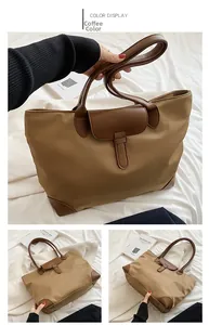 Detail of coffee brown oxford tote bag with leather straps and metallic buckle closure