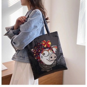 Detail of black sequin tote bag featuring a cute cartoon pig with glasses embroidery