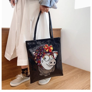 Close-up of the sequined cartoon pig pattern on this large black tote bag for women