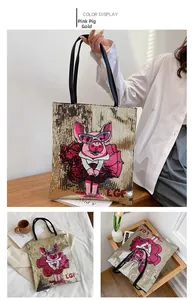 Detail of sequined gold tote bag featuring cartoon pig embroidery and durable handles