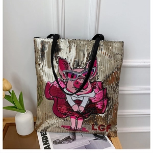 Detail of gold sequin tote bag with cartoon pig design and black leather straps