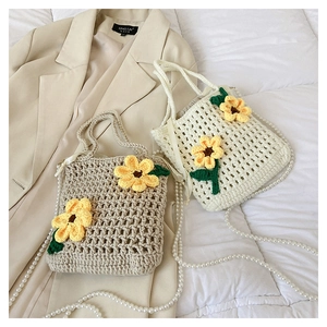 Detailed knit texture of crochet crossbody bag featuring 3D sunflower and pearl chain
